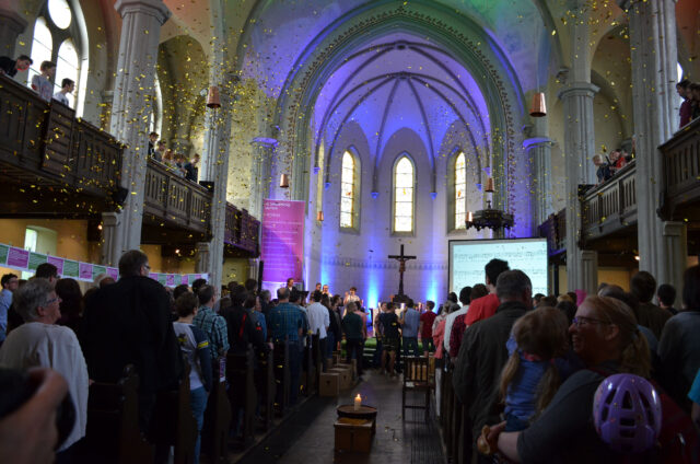 Blick in die volle Friedenskirche, welche mit bläulichem Licht eingeleuchtet ist