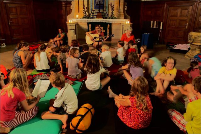 Kinder auf dem Boden vor dem Alter der Michaeliskirche Leipzig singen