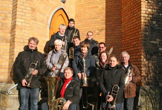 Posaunenchor aufgestellt vor dem Eingang der Friedenskirche